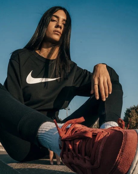 Jugendlicher mit Nike-Shirt und roten Sneakern
