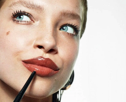 Frau schminkt ihre Lippen