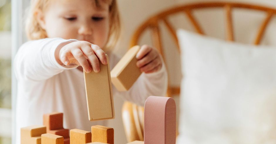 kleines-maedchen-spielt-mit-holzkloetzen